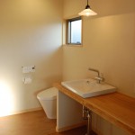 バスルーム2:バスルームには、洗面とトイレがあります。木楽オリジナルの大きな木のカウンターに洗面器をはめ込みました。アイロンかけや朝の身支度にとっても便利なカウンターです。窓からは朝日が差し込むのでお寝坊さんも爽やかな朝を迎えることが出来ます。